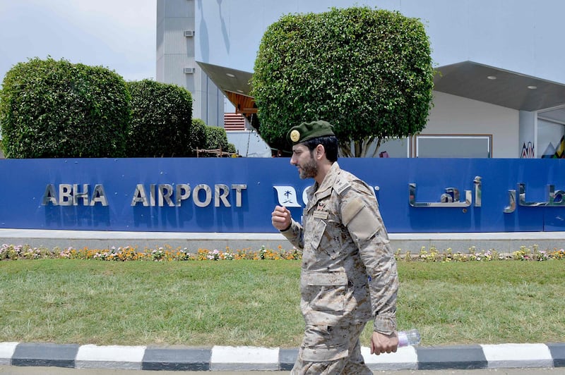 A Saudi serviceman walks by a sign outside Abha airport. AFP