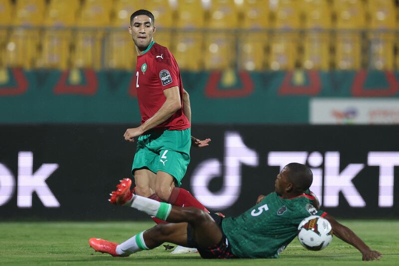 Morocco defender Achraf Hakimi is challenged by Malawi' defender Denis Chembezi. AFP