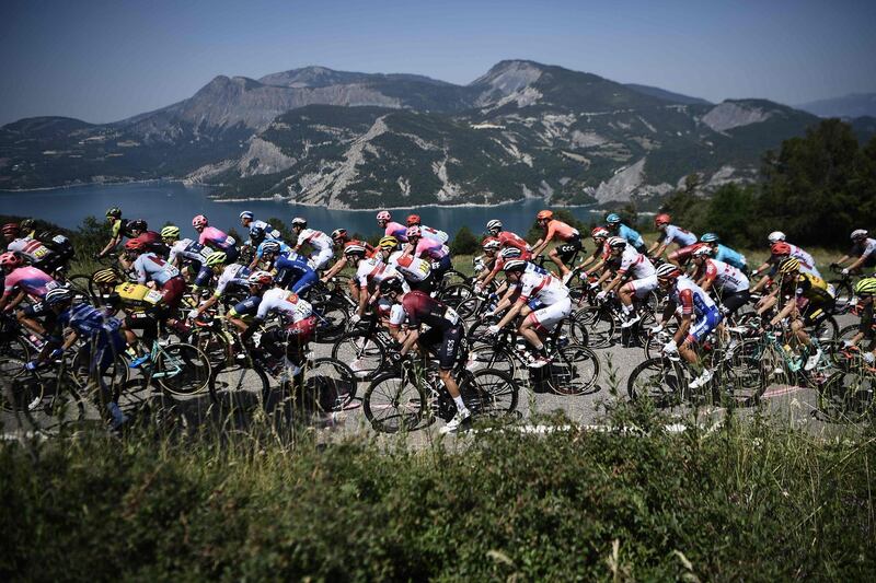 The peleton passes by the Lac de Serre-Poncon during the 18th stage on July 25, 2019.  AFP