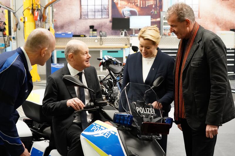 German Chancellor Olaf Scholz sits on a motorcycle at a manufacturing plant in Berlin. EPA