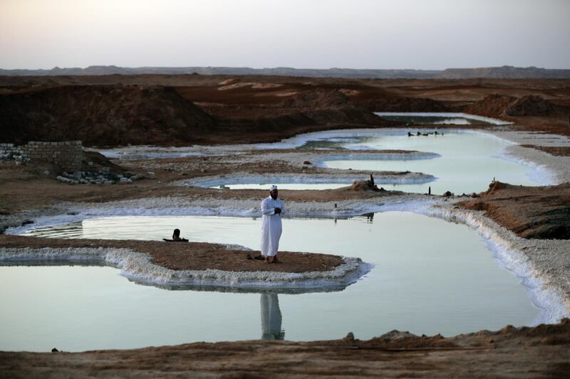 epa07940990 A Siwan prays in a salty lake near the Siwa Oasis, Egypt, 14 October 2019. The people of Siwa traditionally use the salt extracted from the lakes in the region to build their houses and design their tools.  EPA/KHALED ELFIQI