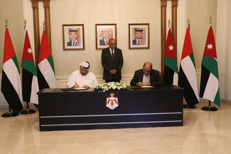 Jordanian Prime Minister Bisher Al Khasawneh, centre, looks on as Mohamed Alsuwaidi, managing director and chief executive of ADQ, left, and Ahmad Al Hanandeh, Jordan’s Minister of Digital Economy and Entrepreneurship, sign the pact. Photo: ADQ