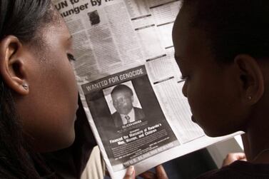 Readers look at a newspaper in Nairobi in 2002 carrying the photograph of Felicien Kabuga after the US issued a $5m reward for his whereabouts. Reuters, file  