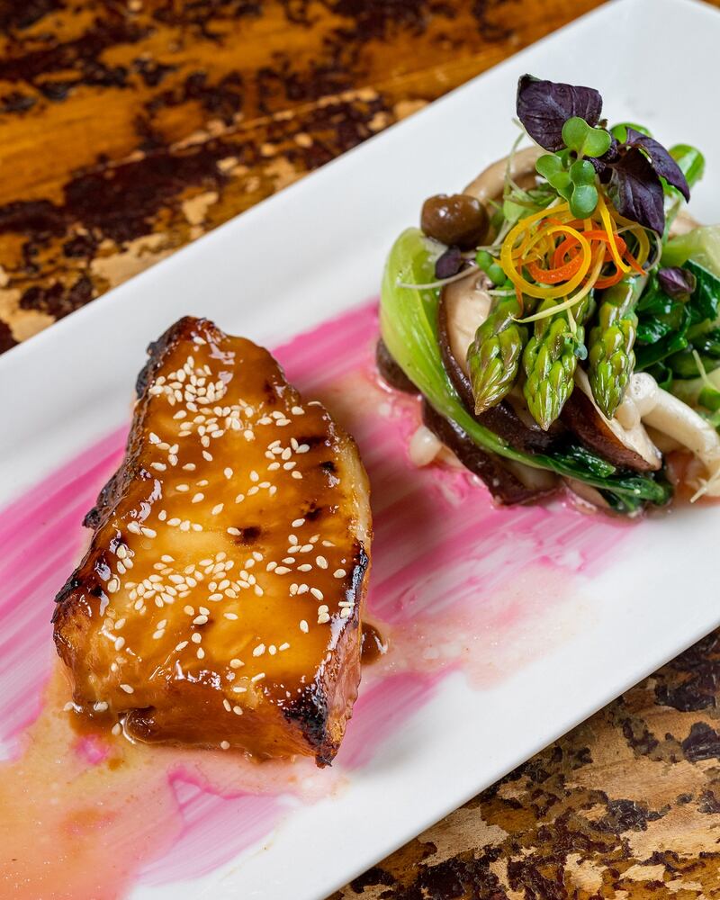 Grilled black fish cod with yellow bean sauce, honey sesame and poached baby vegetables from Hoi An.