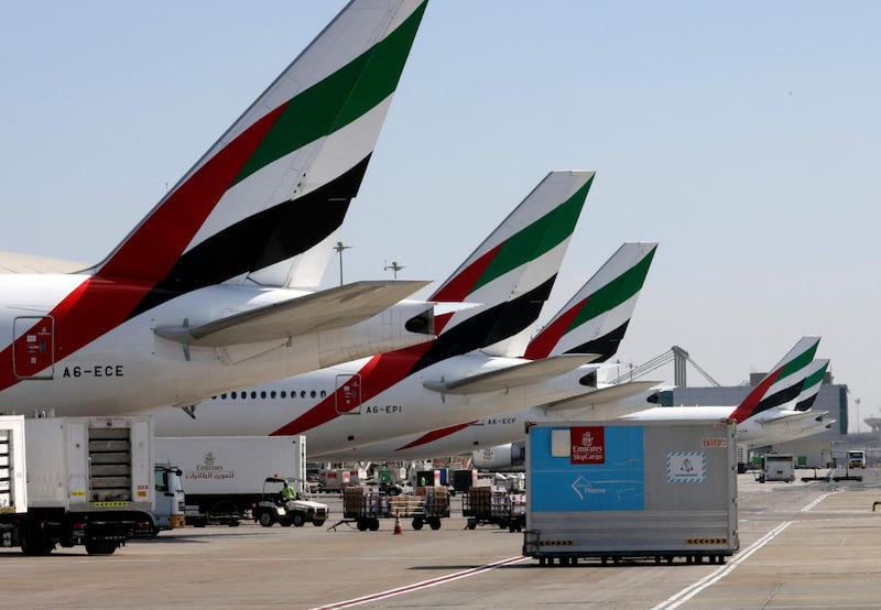 (FILES) In this file photo, an Emirates Airlines Boing 777 plane unloads a coronavirus vaccine shipment at Dubai International Airport on February 1, 2021. Dubai-based Emirates airline on Tuesday posted a $5.5 billion annual loss, its first in more than three decades, after the coronavirus pandemic devastated the aviation industry. / AFP / Karim SAHIB
