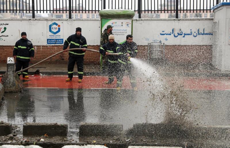 Firefighters wash the site of a suicide attack which targeted the entrance gate of Marshal Fahim Military Academy in Kabul, Afghanistan.  EPA