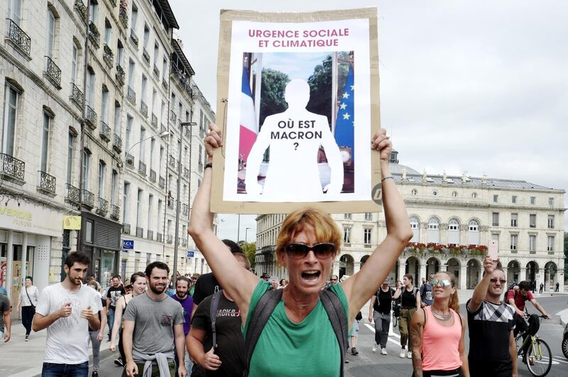 epa07792224 A protestor holding an image of French President Emmanuel Macron during an anti-G7 demonstration in Bayonne, near Biarritz, France, 25 August 2019, on the second day of the G7 summit. Protestors will march with more than 120 portraits of Macron allegedly  stolen in French city halls. The G7 Summit runs from 24 to 26 August in Biarritz.  EPA/FREDERIC SCHEIBER