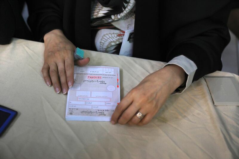 An electoral worker prepares ballot papers for the presidential elections at a polling station in Iran's capital city of Tehran. AP Photo