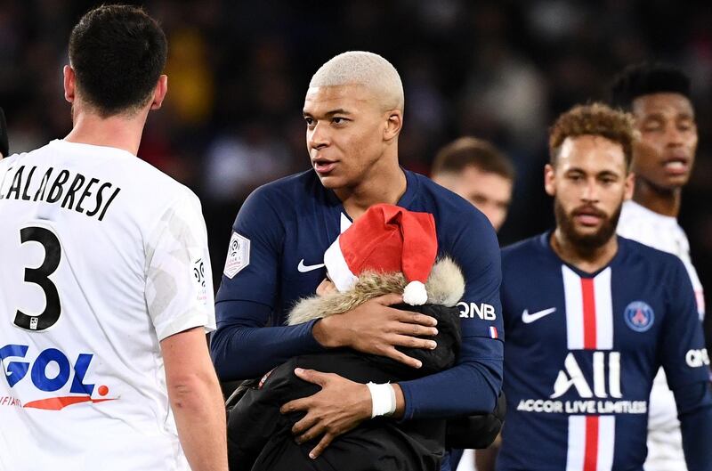 Kylian Mbappe hugs a young fan during the match against  Amiens. AFP