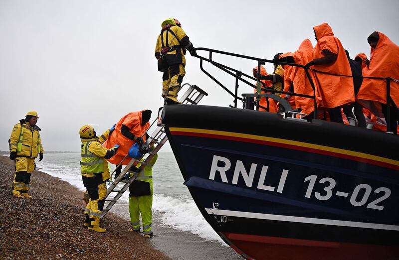 Migrants picked up at sea are helped ashore in England in December. AFP