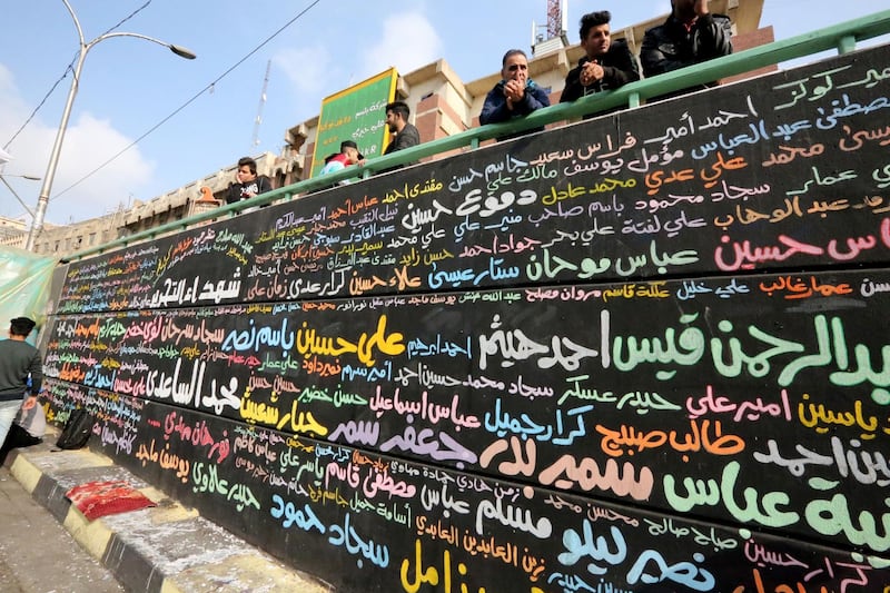 A memorial mural bearing names of demonstrators killed during ongoing anti-government protests is seen in Tahrir square in the capital Baghdad on December 8, 2019. Thousands attended angry protests in Baghdad and southern Iraq today, grieving but defiant after 20 of them were killed in an attack the previous day, in dramatic developments which threaten to derail the anti-government rallies rocking Iraq since October, the largest and deadliest grassroots movement in decades. / AFP / SABAH ARAR
