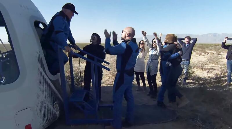 Jeff Bezos, third left, greets Canadian actor William Shatner as he emerges from the capsule after landing near Van Horn, Texas, on October 13. The mission carried Shatner,  Audrey Powers, Blue Origin's vice president of mission and flight operations, and customers Chris Boshuizen and Glen de Vries. EPA
