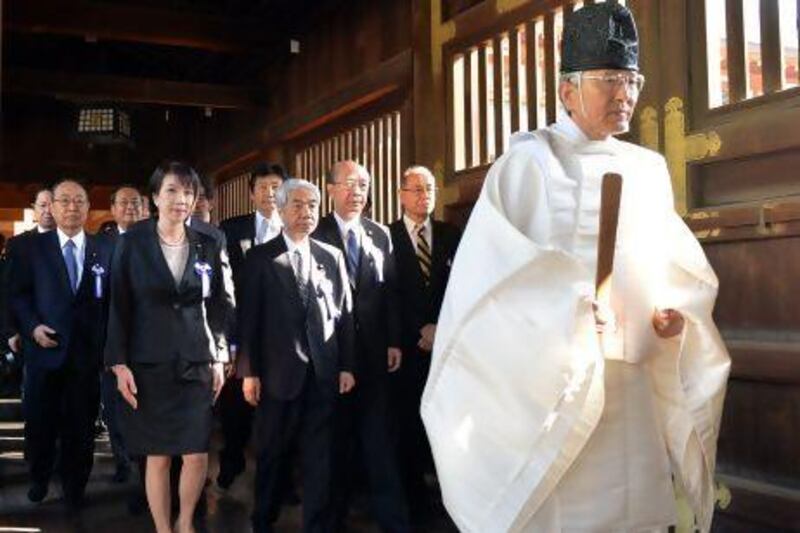 A Shinto priest, right, leads a group of Japanese politicians to offer prayers for the country's war dead at the controversial Yasukuni Shrine in Tokyo.