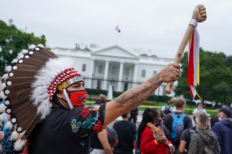 A demonstrator wears a traditional Native American headdress during an Indigenous Peoples' Day protest outside the White House in Washington. Reuters