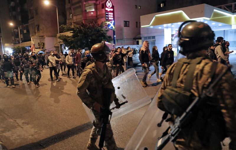 Lebanese army soldiers accompany demonstrators as they chant anti-government slogans while they walk through the streets of the capital Beirut.  AFP