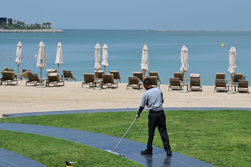 A worker sweeps at Jumeirah Beach Residence in Dubai following the closure of all beaches by authorities.   AFP