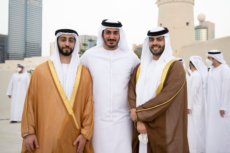 Sheikh Zayed bin Mansour bin Zayed (L) and Sheikh Hazza bin Hamdan bin Zayed (R) pose for a photograph with Sheikh Mohamed bin Sultan bin Khalifa (C) during the group wedding at Qasr Al Hosn.