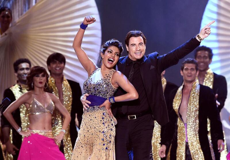 Bollywood actress Priyanka Chopra (L) dances and Hollywood actor John Travolta dance on stage during the fourth and final day of the 15th International Indian Film Academy (IIFA) Awards at the Raymond James Stadium in Tampa, Florida. AFP  

