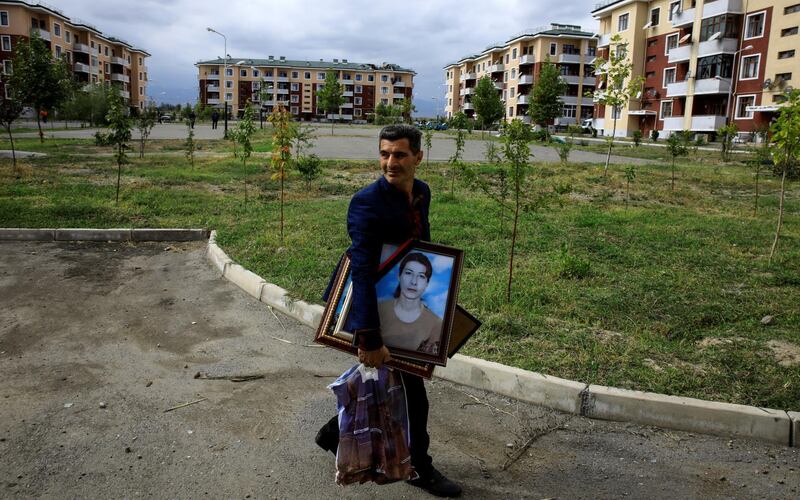 Iman Abisiv carries his belongings from his damaged home after a ceasefire begins during the fighting over the breakaway region of Nagorno-Karabakh in the city of Terter, Azerbaijan. Reuters
