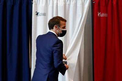 French President Emmanuel Macron stands by a voting booth during the first round of French regional and departmental elections, in Le Touquet-Paris-Plage, northern France, Sunday, June 20, 2021. The elections for leadership councils of France's 13 regions, from Brittany to Burgundy to the French Riviera, are primarily about local issues like transportation, schools and infrastructure. But leading politicians are using them as a platform to test ideas and win followers ahead of the April presidential election. (Christian Hartmann/Pool via AP)