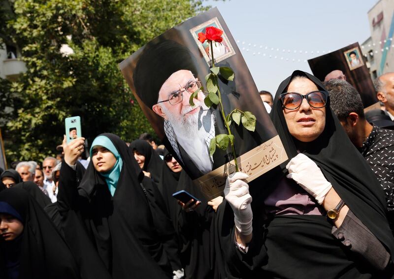 epa07676574 Iranians hold posters depicting Iranian supreme leader Ayatollah Ali Khamenei mourn during a ceremony in Tehran, Iran, 27 June 2019, marking the return of bodies of Iranian soldiers killed in the Iran-Iraq war. According to reports, some 150 bodies of soldiers killed in the Iran-Iraq war of 1980 and 1988 were recovered in battlefields. Hundreds of thousands of Iranians are thought to have been either killed or went missing during the conflict, with some of their bodies found in recent years.  EPA/ABEDIN TAHERKENAREH