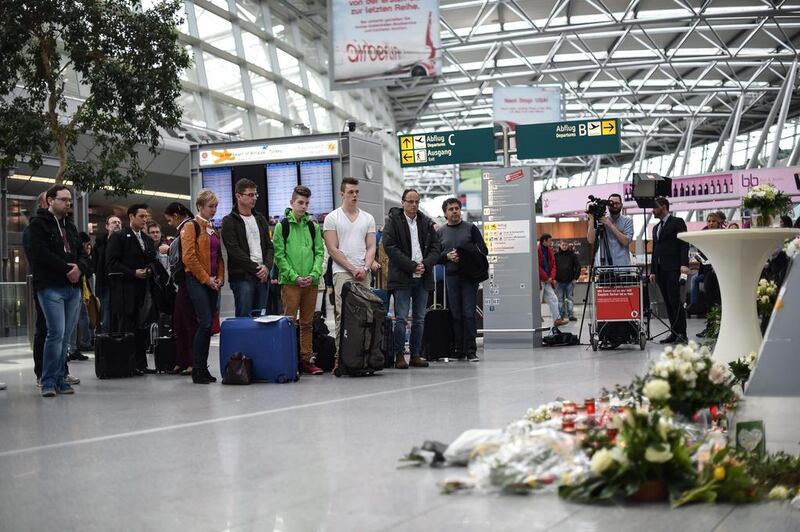 Visitors and travelers stand in a moment of silence on March 26, 2015 at a memorial desk set up in commemoration of the victims of the Germanwings plane crash at the airport in Duesseldorf where the jet was due to land. Maja Hitij/EPA