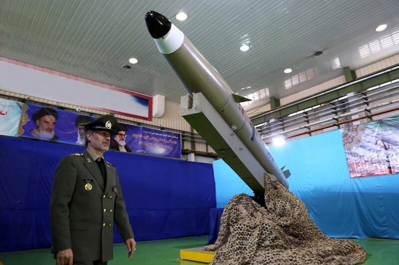 In this picture released by the official website of the Iranian Defense Ministry on Monday, Aug. 13, 2018, Defense Minister Gen. Amir Hatami walks past the missile Fateh-e Mobin, or Bright Conqueror, during inauguration of its production line at an undisclosed location, Iran. Iran on Monday said it launched a production line for a radar-evading, short range surface-to-surface missile capable of hitting targets in any weather condition. (Iranian Defense Ministry via AP)