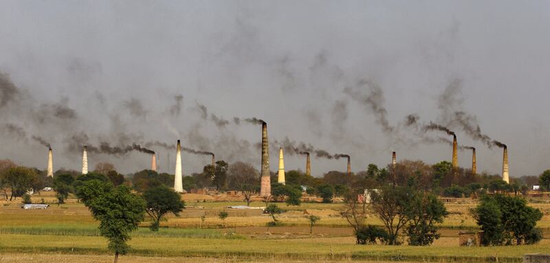 Smoke rises from brick kiln chimneys on the outskirts of New Delhi. India is the world's third-largest carbon emitter, and under the Paris Agreement has pledged to reduce its emissions intensity to between 33 per cent and 35 per cent by 2030. AP