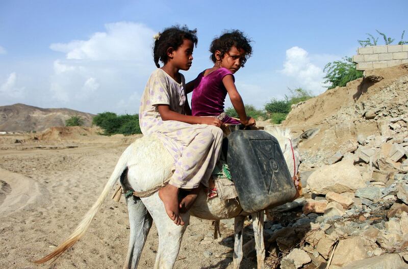 Children riding a donkey return home with jerrycans filled with water from a cistern, at a make-shift camp for displaced Yemenis in the northern Hajjah province on April 29, amid a severe shortage of water.  Yemen has suffered years of war that have driven millions from their homes and plunged the country into the world's worst humanitarian crisis. Essa Ahmed/ AFP