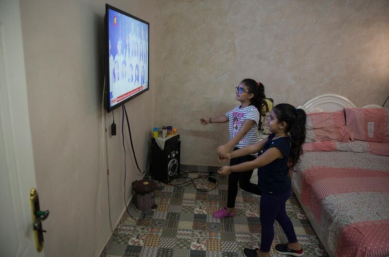 Coptic girls reacting while watching hymns performed on telelvision at home at Shubra Al Khema district in Cairo, Egypt.  EPA