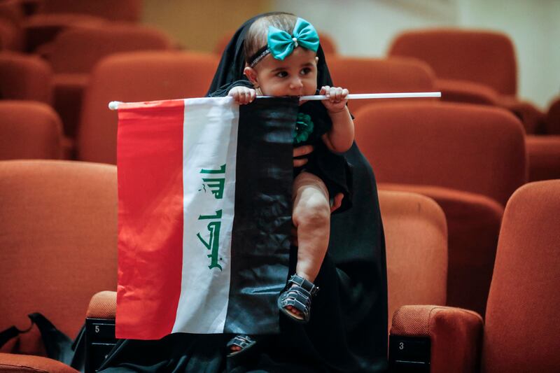 A Iraqi toddler holds the country's flag inside the parliament building. AFP