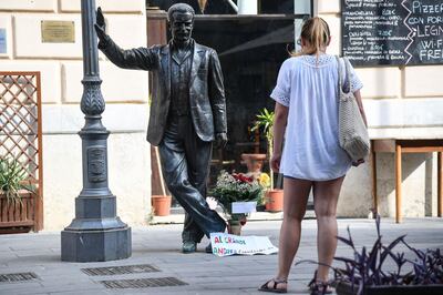 A woman looks at the statue of "Inspector Salvo Montalbano", a character created by Italian writer Andrea Camilleri, in the central street of the village, Porto Empedocle, the native place of Camilleri, near Agrigento, Sicily, on July 17, 2019. Italian author Andrea Camilleri, who earned worldwide acclaim for his series of 30-odd whodunnits starring inspector Salvo Montalbano in the fictitious Sicilian city of Vigata, died on July 17, 2019 aged 93. Born in Porto Empedocle, Sicily, Camilleri saw his works turned into a TV series in 1999 that was picked up in Britain, the United States and Australia. "I love him and I hate him. I owe him practically everything, he opened the door for the other books," Camilleri said about Montalbano in an interview with Italy's La Stampa newspaper. He died in a Rome hospital after a period in intensive care.  / AFP / Andreas SOLARO
