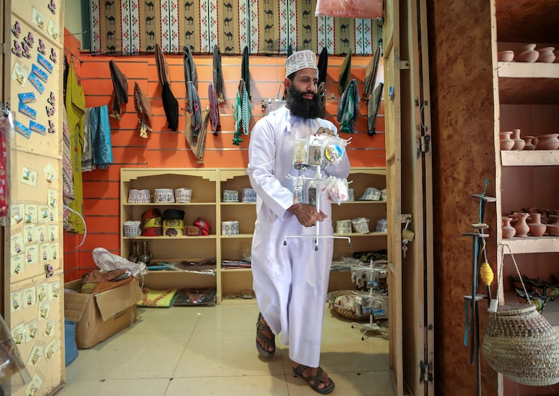 A shop owner brings out his wares. Some sections of the souq have retained its ancient architecture and unrenovated structures.