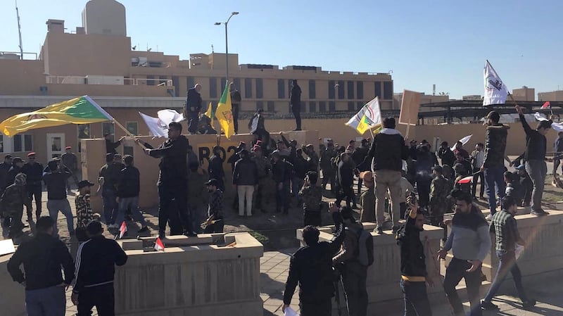 Protesters and militia fighters gather outside the main gate of the US embassy in Baghdad. @SaadoonMustafa via Twitter