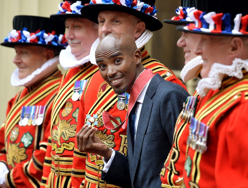 Farah holds his CBE medal at Buckingham Palace, after he received the award in 2013. PA