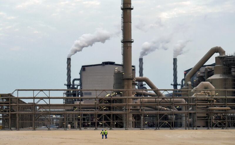 Emloyees walk outside the Maaden Aluminium Factory in Ras Al-Khair Industrial area near Jubail City, 570 kms east of the Saudi capital Riyadh, on November 23, 2016. - Maaden Aluminium is a joint venture between the Saudi Arabian Mining Company (Maaden) and Alcoa, the third largest producer of aluminium in the world. (Photo by FAYEZ NURELDINE / AFP)