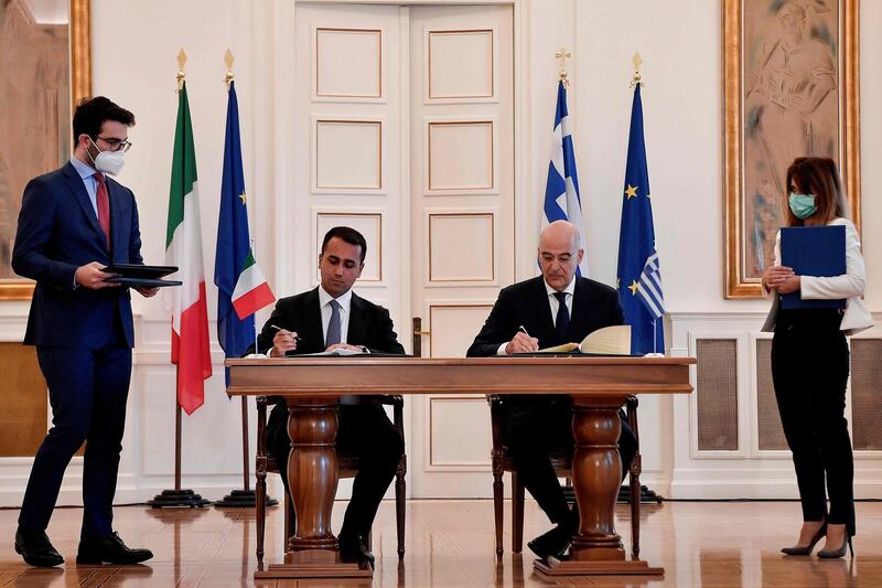 Greek Foreign Minister Nikos Dendias (R) and his Italian counterpart Luigi Di Maio sign a maritime zone agreement at the Foreign Ministry in Athens on June 9, 2020.  / AFP / Louisa GOULIAMAKI
