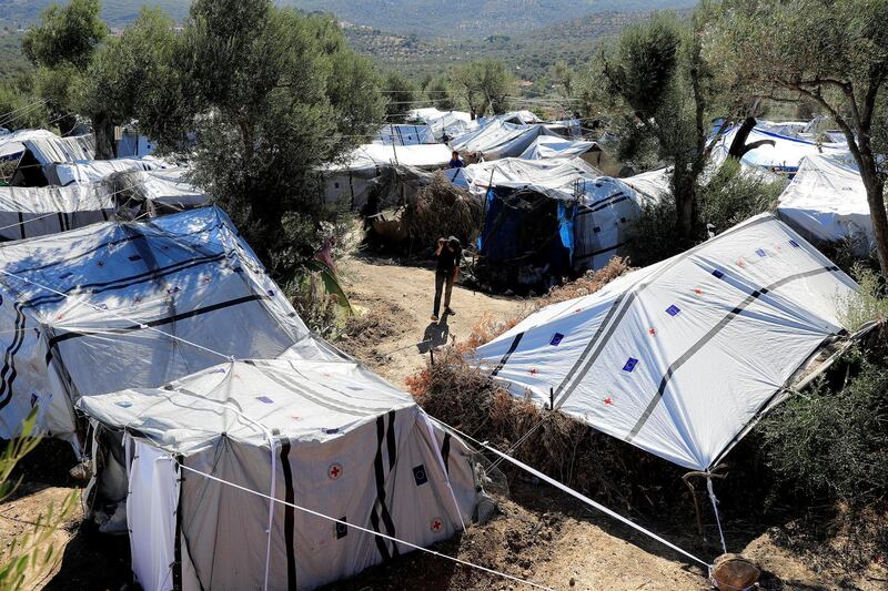 A migrant walks among tents at a makeshift camp next to the Moria camp for refugees and migrants on the island of Lesbos, Greece, September 18, 2018. Picture taken September 18, 2018. REUTERS/Giorgos Moutafis