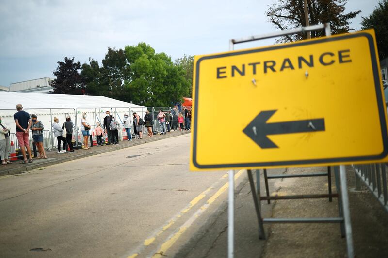 A sign is seen as people queue at a test centre following an outbreak of the coronavirus disease (COVID-19) in Southend-on-sea, Britain September 15, 2020.  REUTERS/Hannah McKay