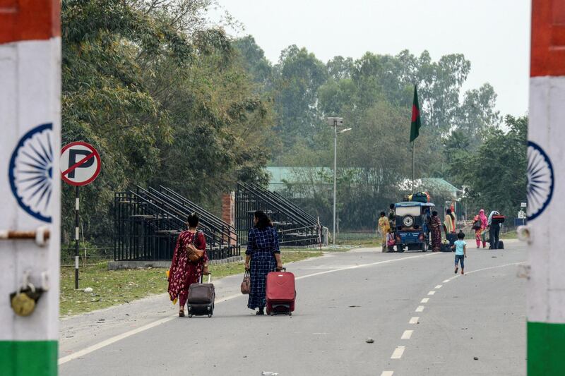 Bangladeshi nationals pull their luggage after they cross the Indian side, following an announcement about the closure of the India-Bangladesh border as a preventive measure against the spread of the COVID-19 coronavirus, at Fulbari Border checkpoint, some 16 kms from Siliguri on March 13, 2020. (Photo by DIPTENDU DUTTA / AFP)