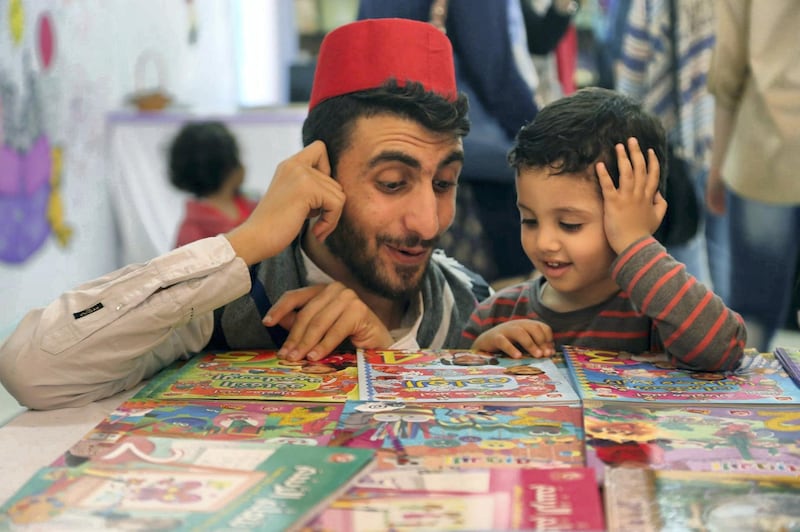 Storyteller Mohammed Al-Amoudi with children at a Gaza book exhibition.