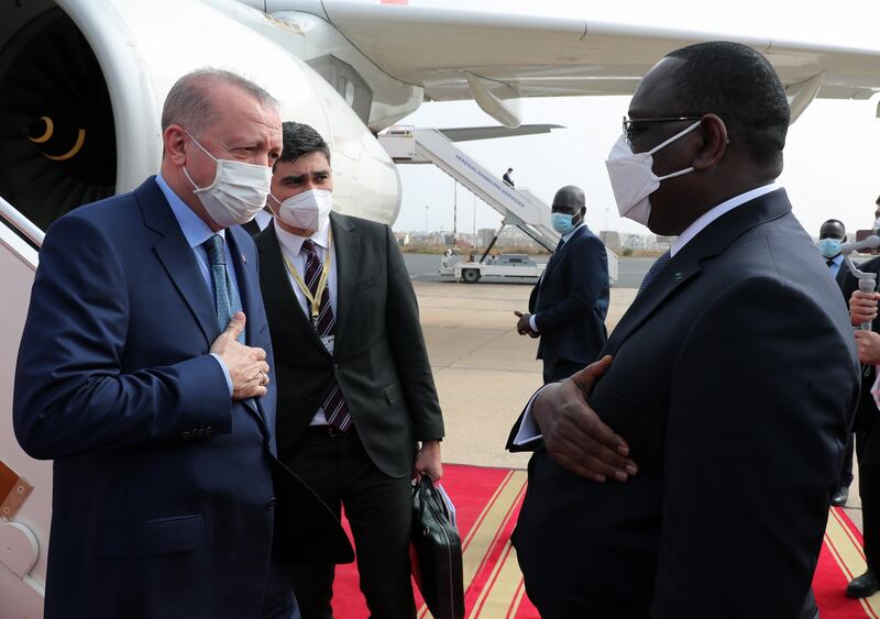 Mr Sall, right, welcomes Mr Erdogan at the airport in Dakar. EPA / Turkish President Press Office Handout