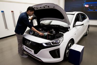An employee inspects the engine room of a Hyundai Motor Co. Ioniq electric vehicle at the Hyundai Motorstudio showroom in Hanam, South Korea, on Tuesday, July 24, 2018. Hyundai is scheduled to release second-quarter results on July 26. Photographer: SeongJoon Cho/Bloomberg