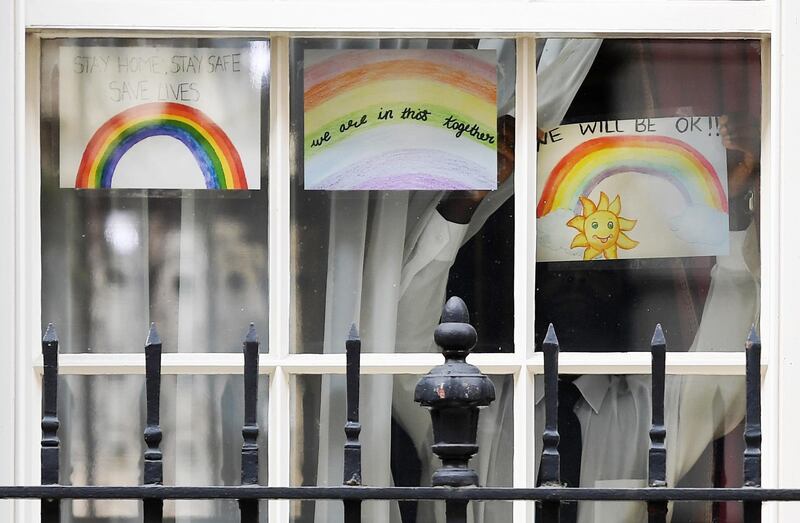 A child places a rainbow drawing in the window of No 10 Downing Street in London, Britain.  EPA
