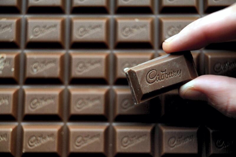 BRISTOL, ENGLAND - JANUARY 19:  In this photograph illustration a woman picks up a chunk of chocolate from a bar of Cadbury's Dairy Milk chocolate on January 19, 2010 in Bristol, England. The US food giant Kraft has today agreed a takeover of Dairy Milk maker Cadbury in a deal worth 11 billion GBP, however many Cadbury workers remained concerned over the longterm future of their jobs.  (Photo by Matt Cardy/Getty Images)