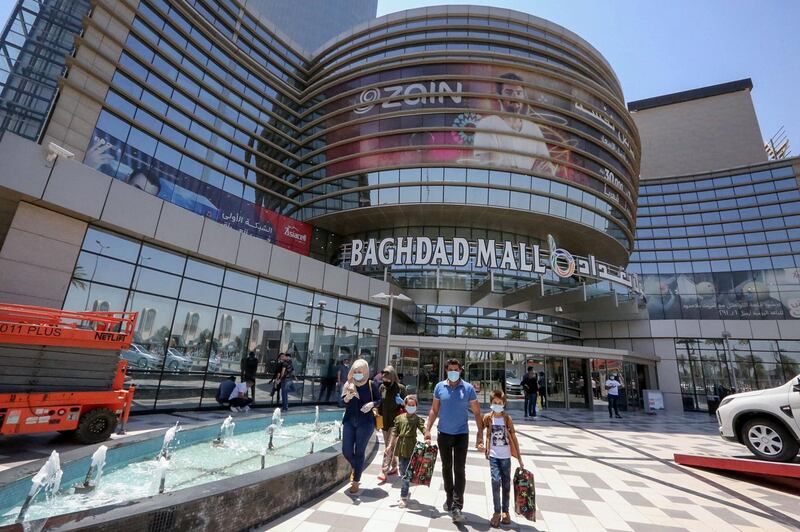 Iraqis wearing protective masks leave after shopping at the Mall of Baghdad as it reopens after a long closure due to the COVID-19 pandemic, in the Al-Harithiya area of the capital Baghdad, on July 19, 2020. / AFP / SABAH ARAR
