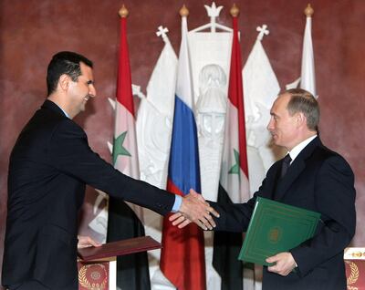 Russian President Vladimir Putin (R) shakes hands with his Syrian counterpart Bashar al-Assad during the signing ceremony in the Moscow's Kremlin, 25 January 2005. Russia and Syria have reached a deal on restructuring debt owed by Syria left over from the Soviet era, the Syrian and Russian presidents announced after Kremlin talks. AFP PHOTO / POOL / SERGEI CHIRIKOV (Photo by SERGEI CHIRIKOV / POOL / AFP)