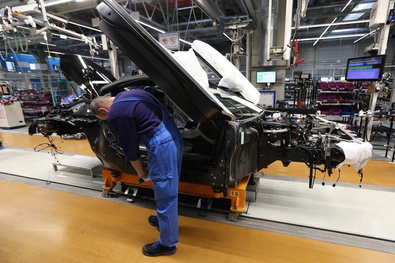 An employee secures a dihedral door frame fitting on a BMW i8 hybrid electrical automobile at the Bayerische Motoren Werke AG factory in Leipzig, Germany, on Thursday, March 14, 2019. Chancellor Angela Merkel's plan to hatch a German battery-cell industry from scratch is gaining momentum as Europe's biggest economy tries to lower emissions while keeping Chinese automobile competition at bay. Photographer: Krisztian Bocsi/Bloomberg