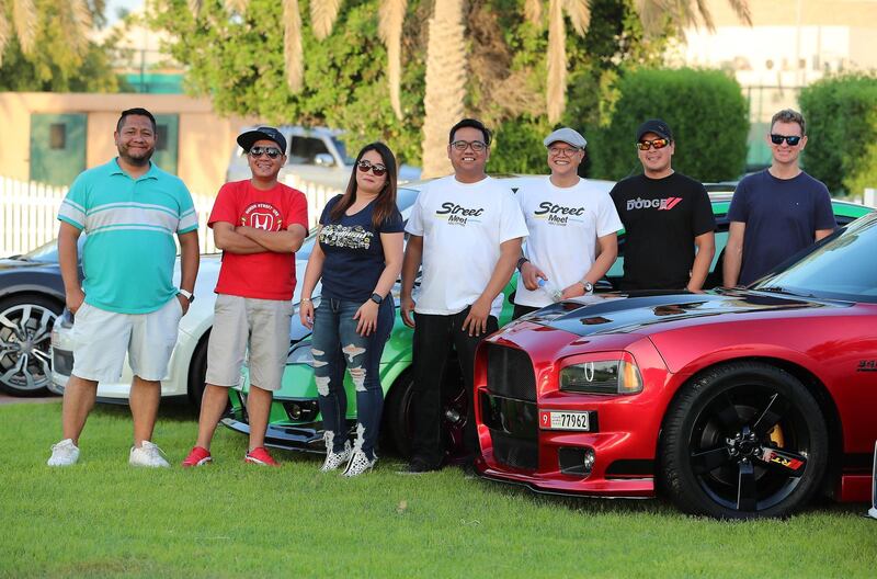ABU DHABI , UNITED ARAB EMIRATES ,  October 14 , 2018 :- Left to Right ��� David Granados , Louie Manalac , Myra Madera , Zingiber Umali ( organizer ) , Glenn Navarro ( organizer ) , Arnold Quimio and Paul Newmark with the Modified cars for the StreeMeet car show which will be taking place on 26th October at the Abu Dhabi City Golf Club in Abu Dhabi. ( Pawan Singh / The National )  For Weekend. Story by Adam Workman
