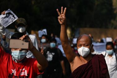 A monk holds up the three finger salute during a demonstration against the military coup in Yangon on February 7, 2021. AFP 